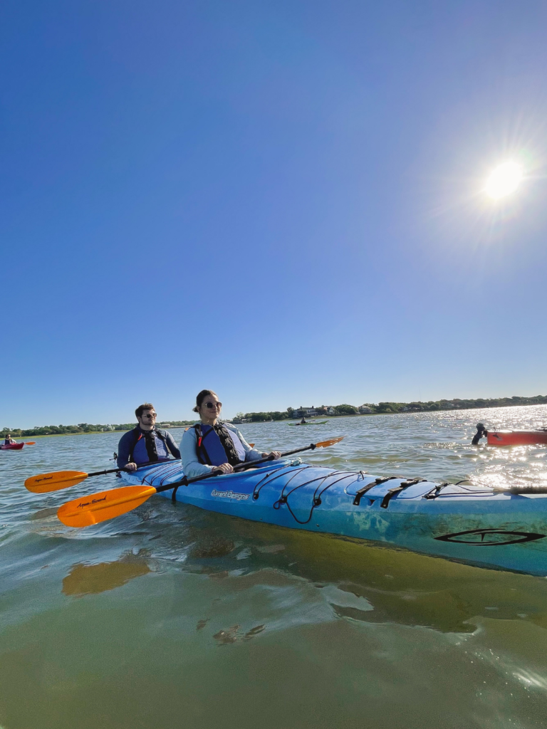 two adults kayaking in a tandem kayak on the ocean