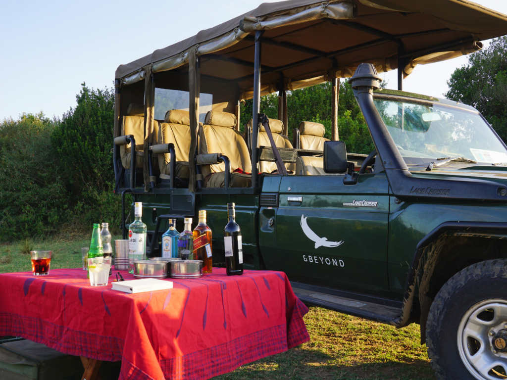 Safari jeep parked with a table set up for traditional sundowners in Africa